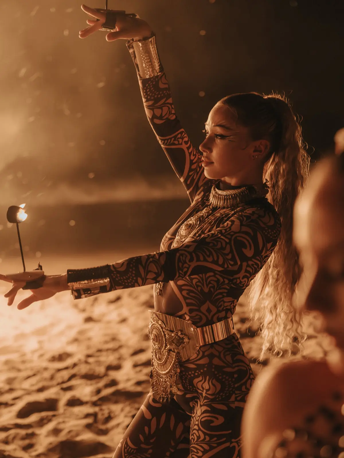 A fire performer on the beach at night
