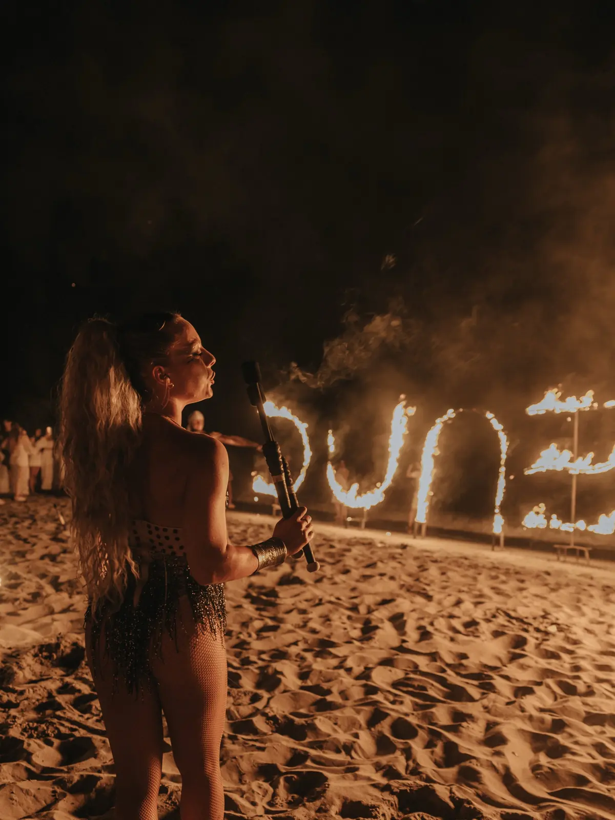 The name Dune written in fire on the sand during a night performance