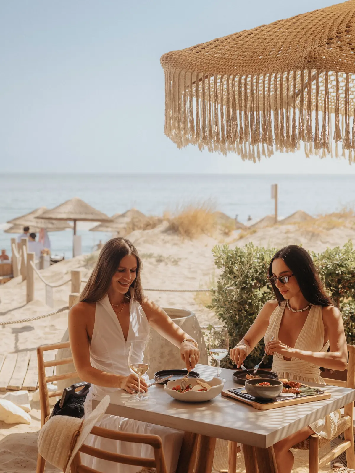 Two guests having lunch at a terrace table facing the sea