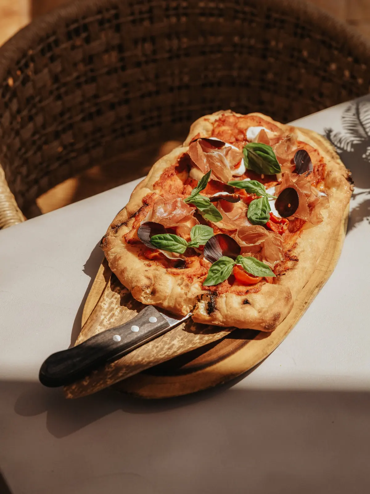 Pinsa Dolce Parma on a wooden board on the terrace