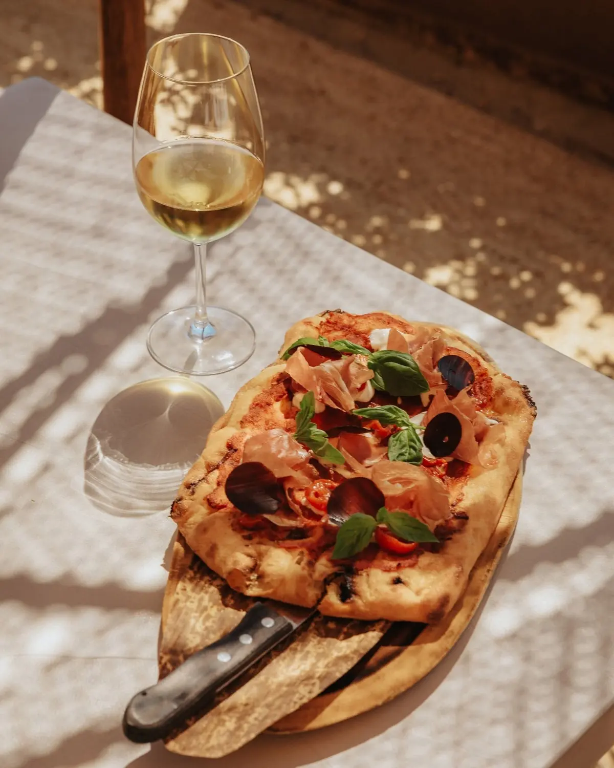Pinsa and a glass of white wine in the sun