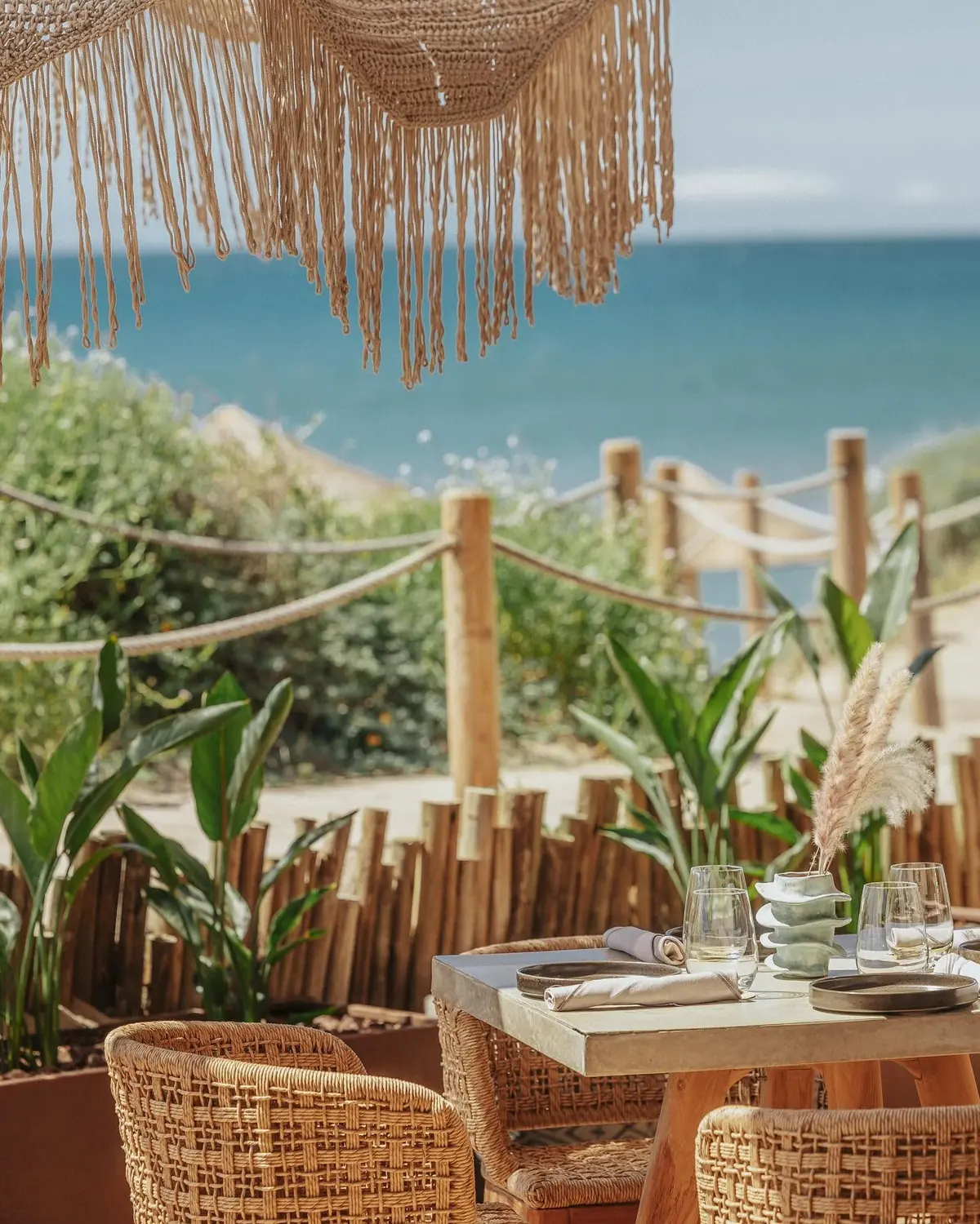 A table set on the terrace beside the protected dunes and the sea